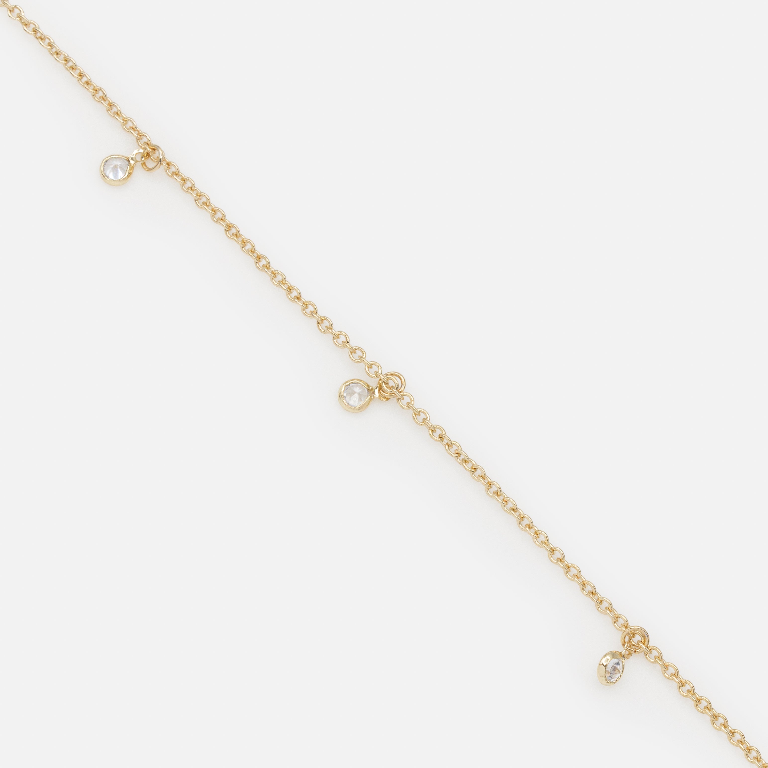Gold bracelet with small round charms and cubic zirconia
