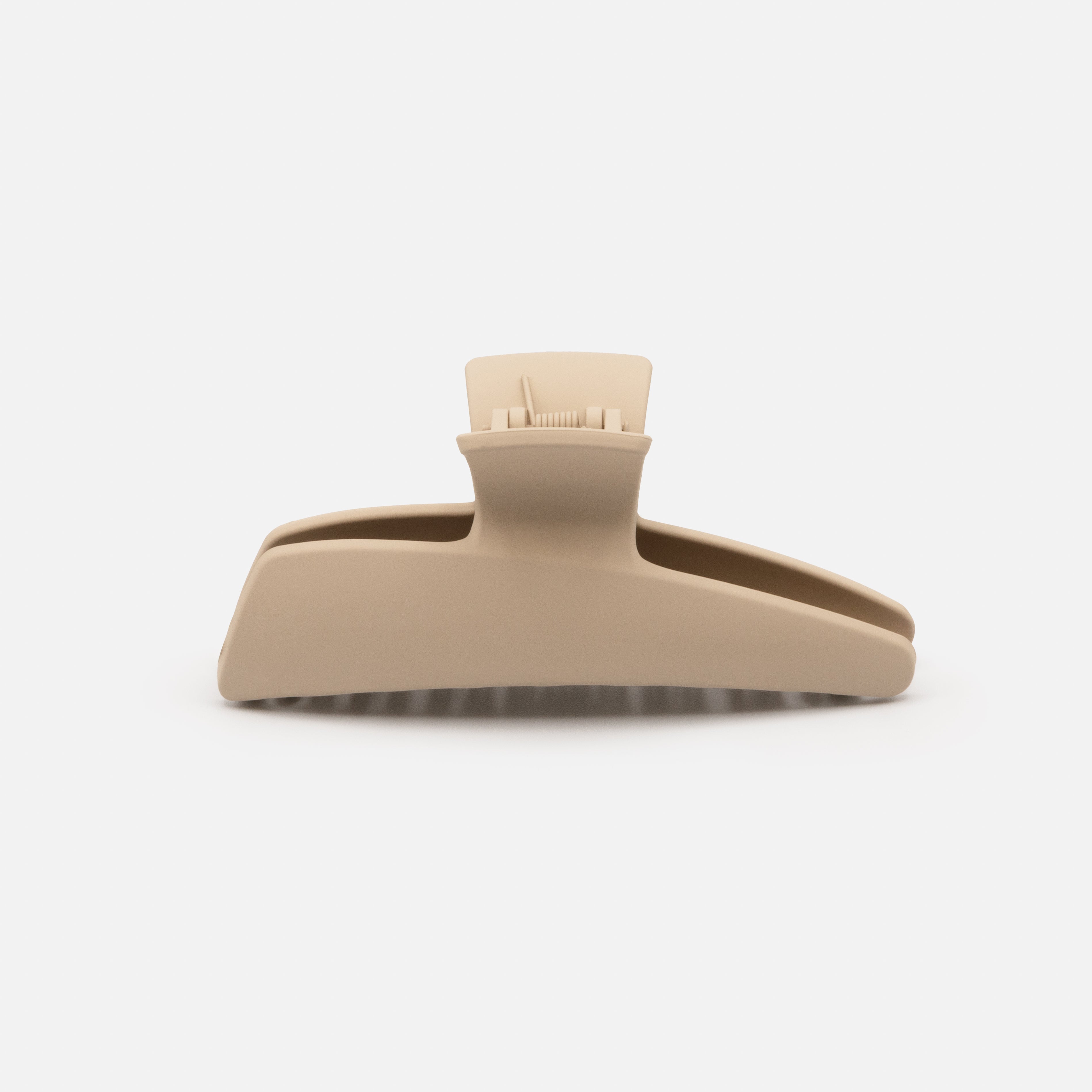 Beige geometric plastic clip with a matte finish