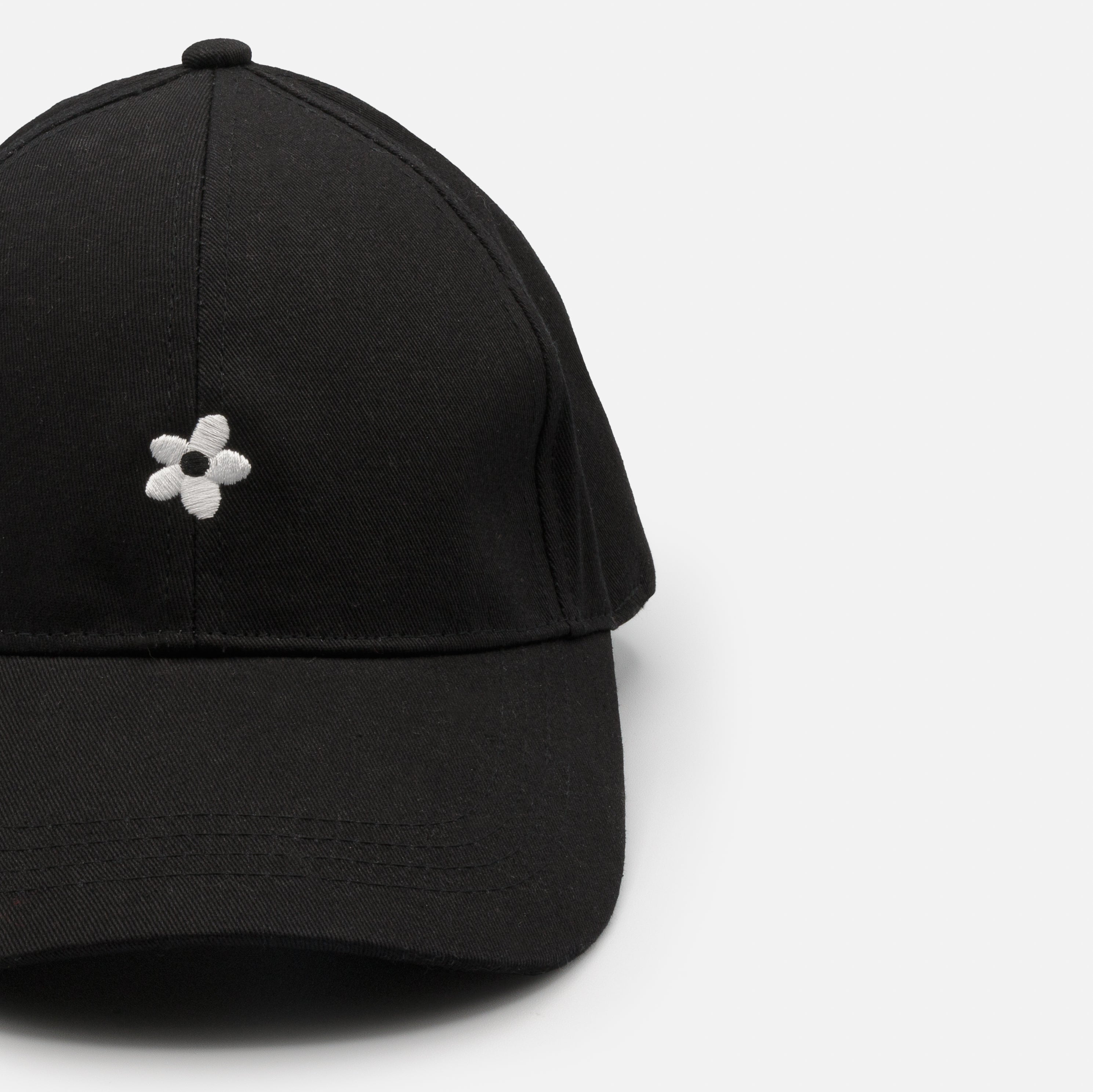 Casquette noire avec broderie fleur blanche