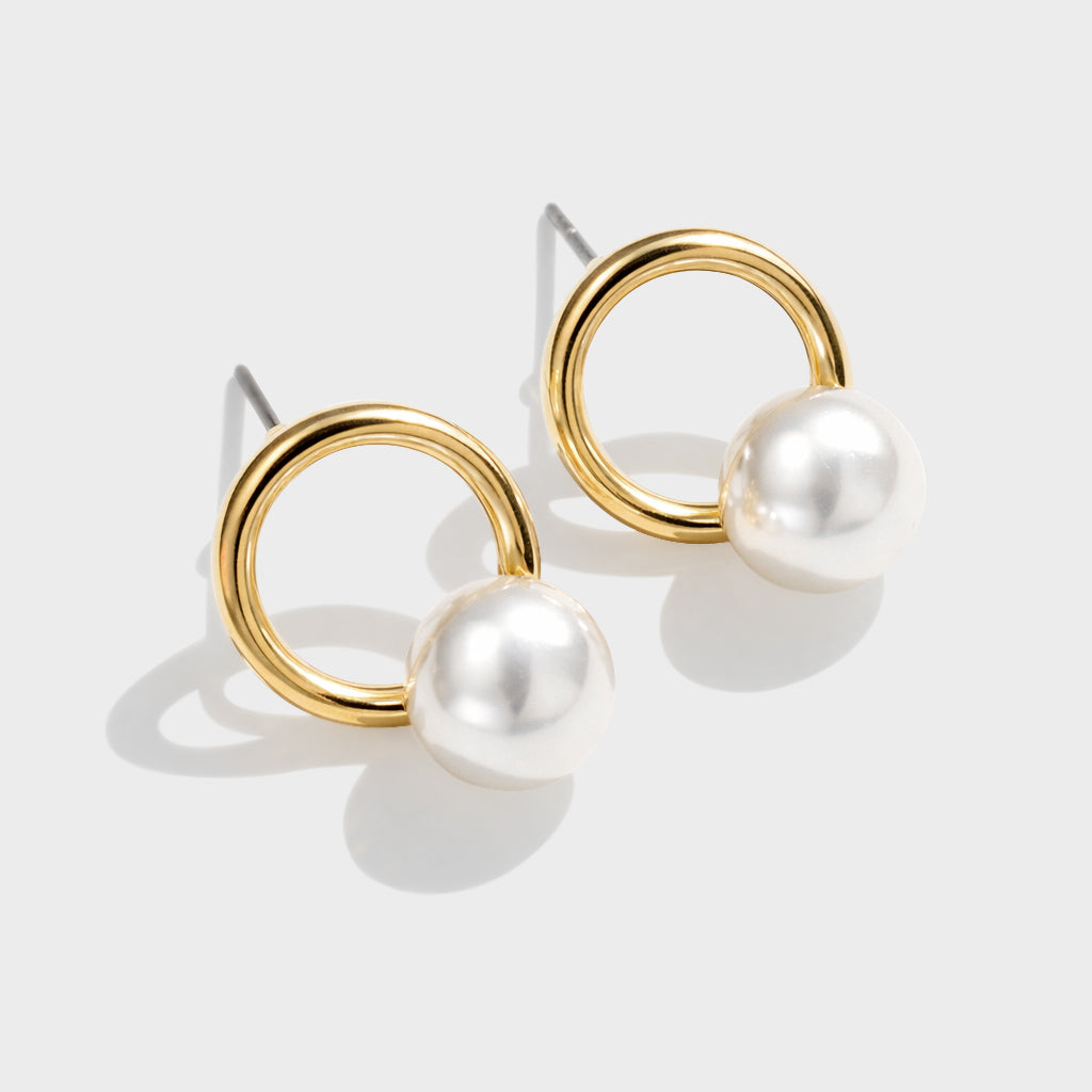 Gold-plated half-pearl earrings on a ring