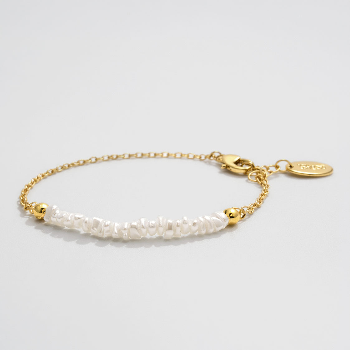 Bracelet doré délicat à rangée de perles asymétrique