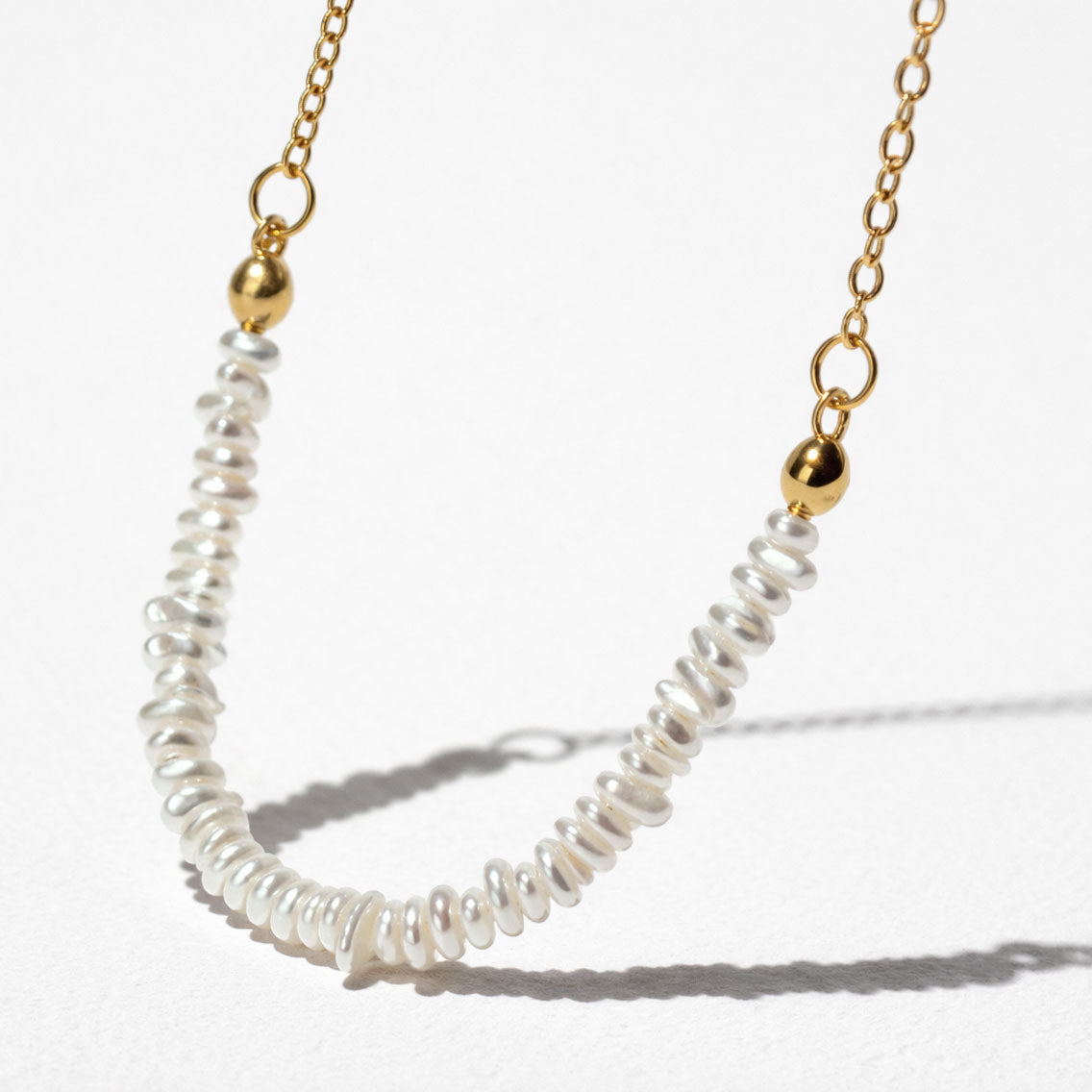 Collier doré délicat à rangée de perles asymétrique