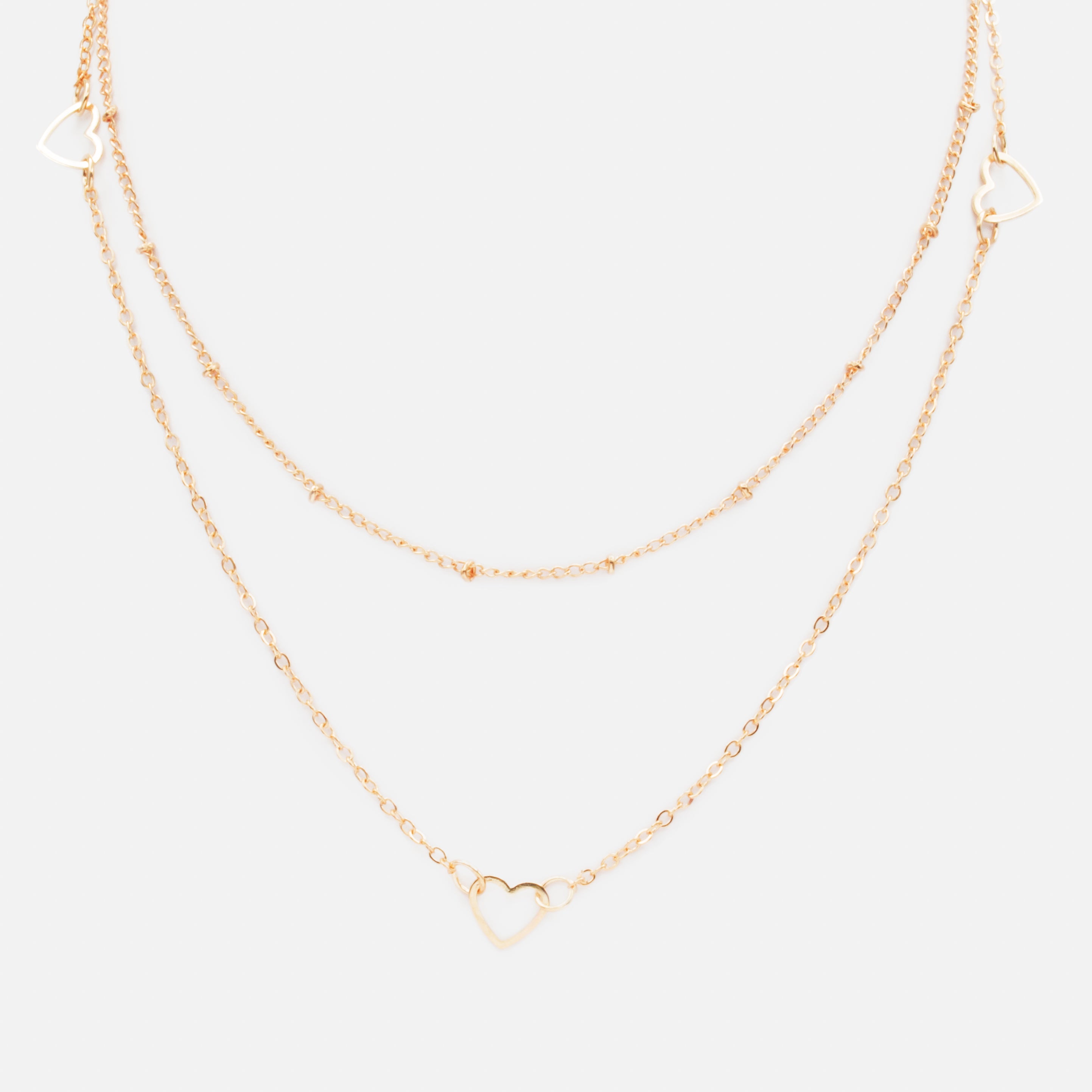 Collier doré double chaîne avec trio de coeurs