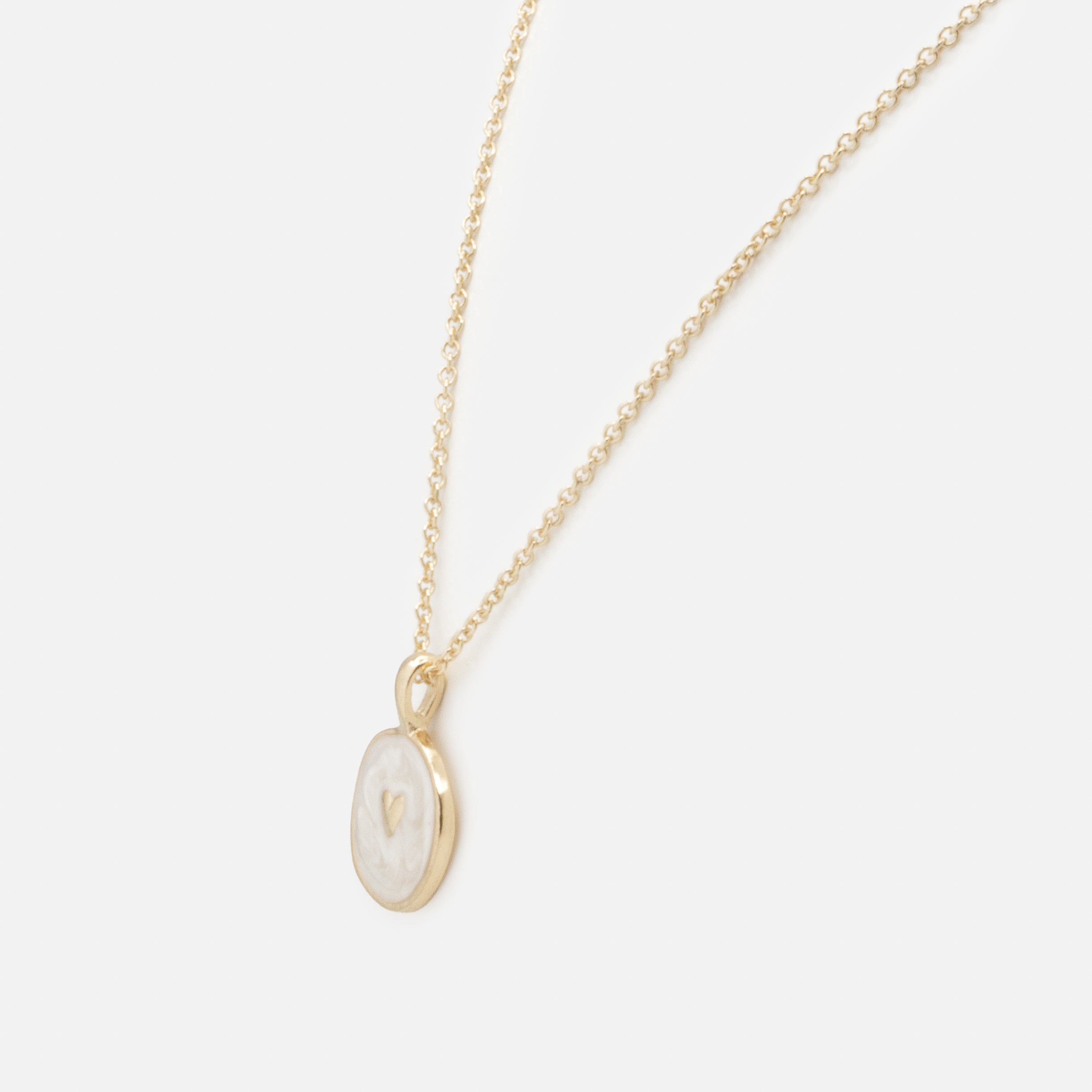 Collier doré petit cœur sur fond blanc nacré