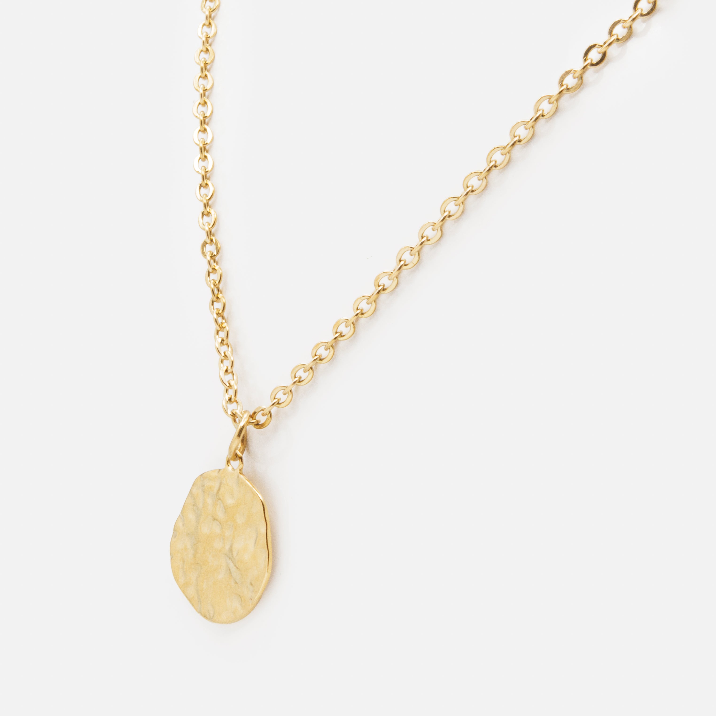 Gold necklace with imperfect hammered circle in stainless steel