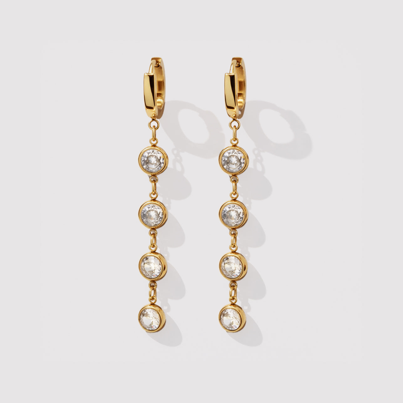 Bizou SF253E005GL – Gold huggie hoop earrings with four bezel-set cubic zirconia drop chain, stainless steel, front view, Bizou jewelry