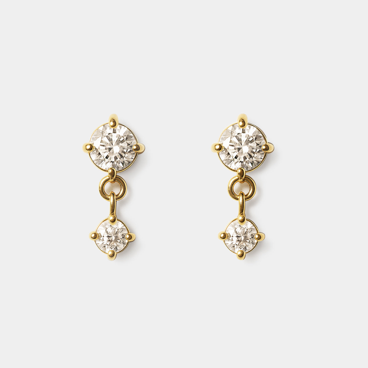 Bizou SS253E011GL – Gold double cubic zirconia drop earrings in stainless steel, two prong-set CZ stones linked by gold ring, front view
