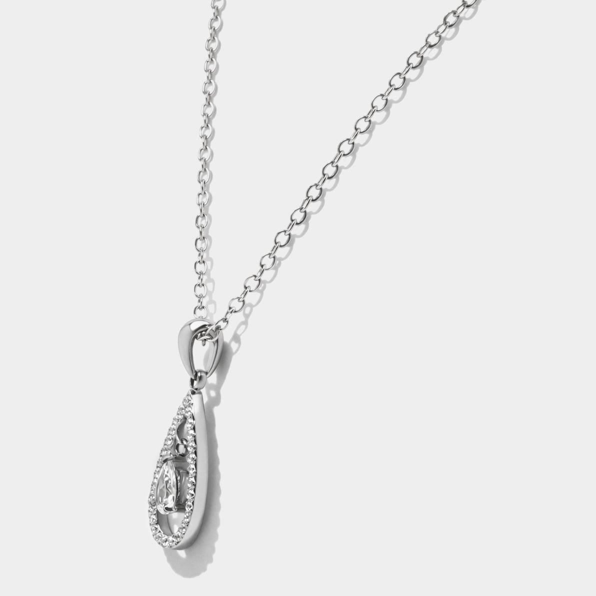 Bizou SS253N018SL – Side view of silver stainless steel pavé teardrop necklace showing floating pear-cut CZ inside open drop pendant, Bizou jewelry