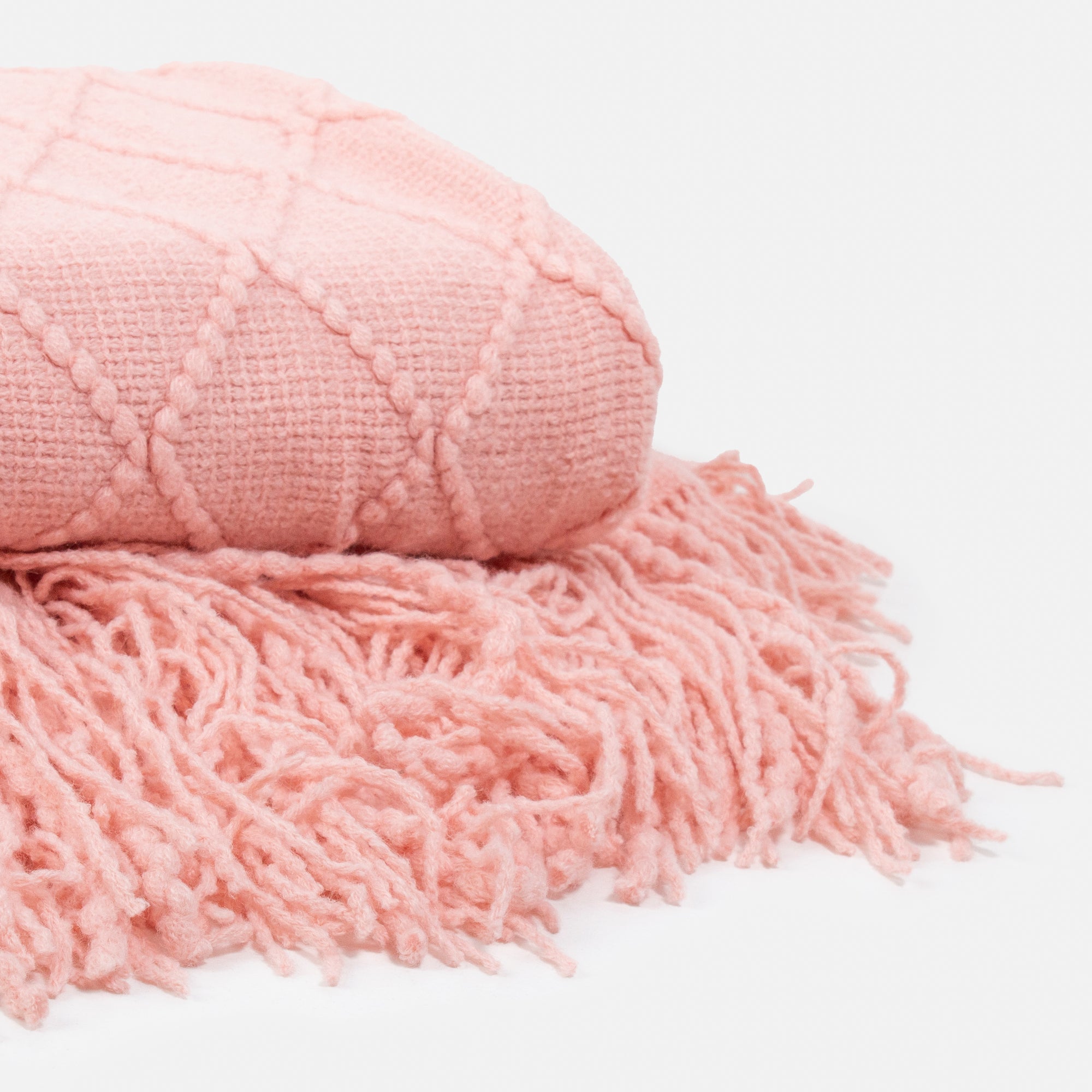 Pale pink blanket with diamond patterns and fringes