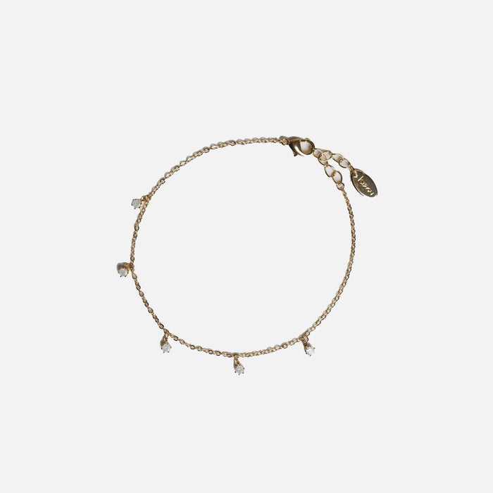 Bracelet doré avec petites breloques en zircons