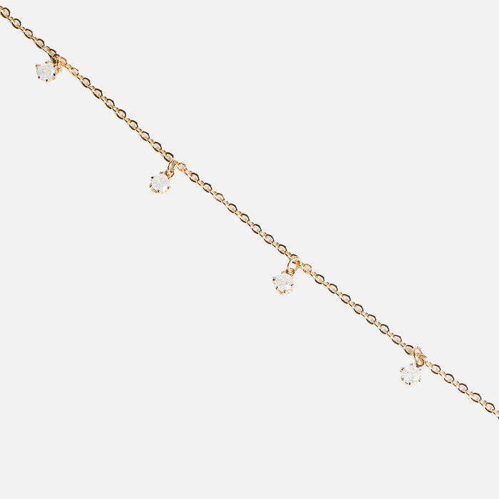 Bracelet doré avec petites breloques en zircons
