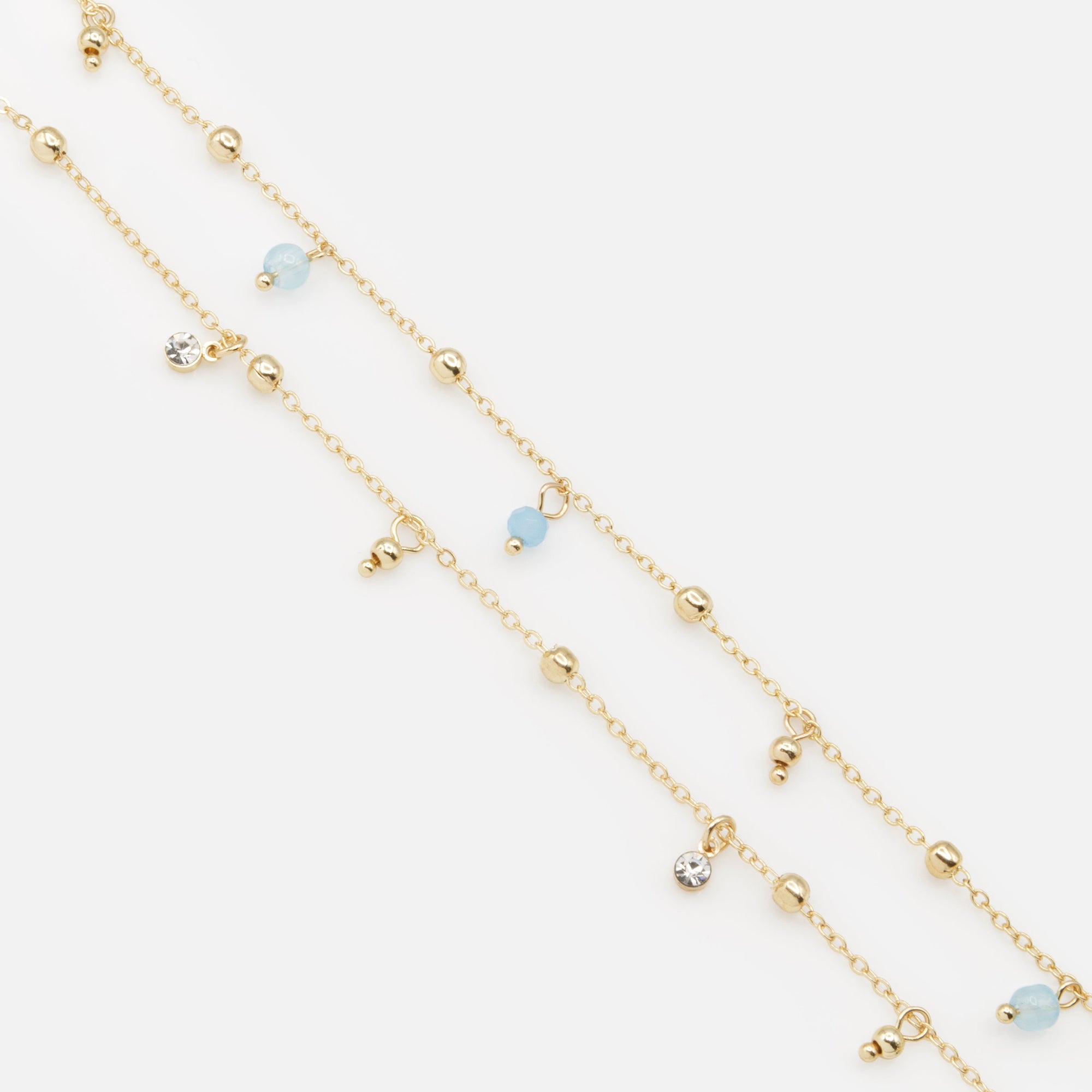 Pair of gold ankle chains with blue beads