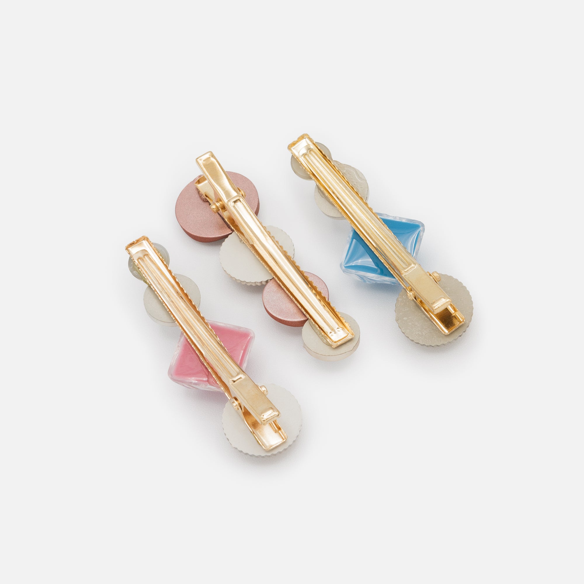 Set of three golden clips with blue and pink stones