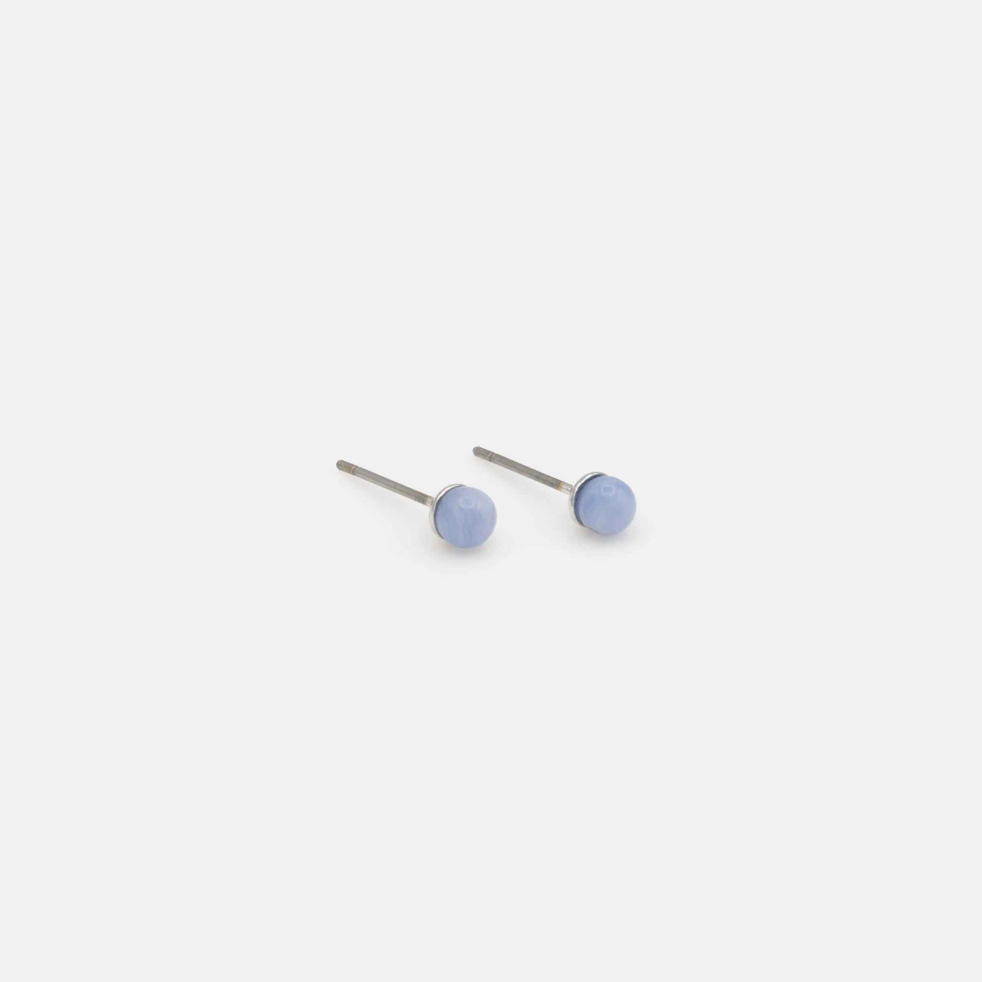 Fixed silver earrings with pale blue round stone