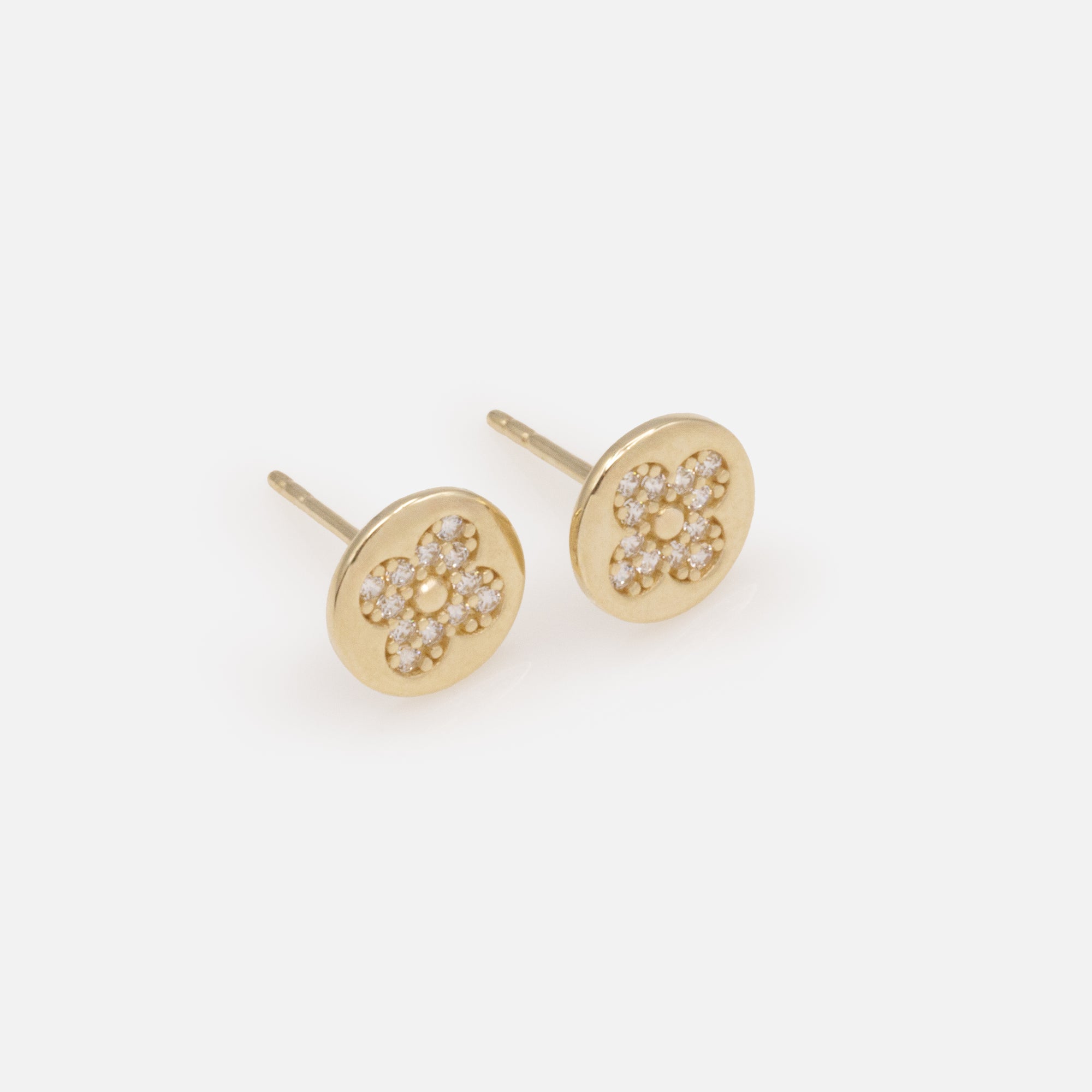 Small cubic zirconia flower earrings on a gold background in 10 carat gold