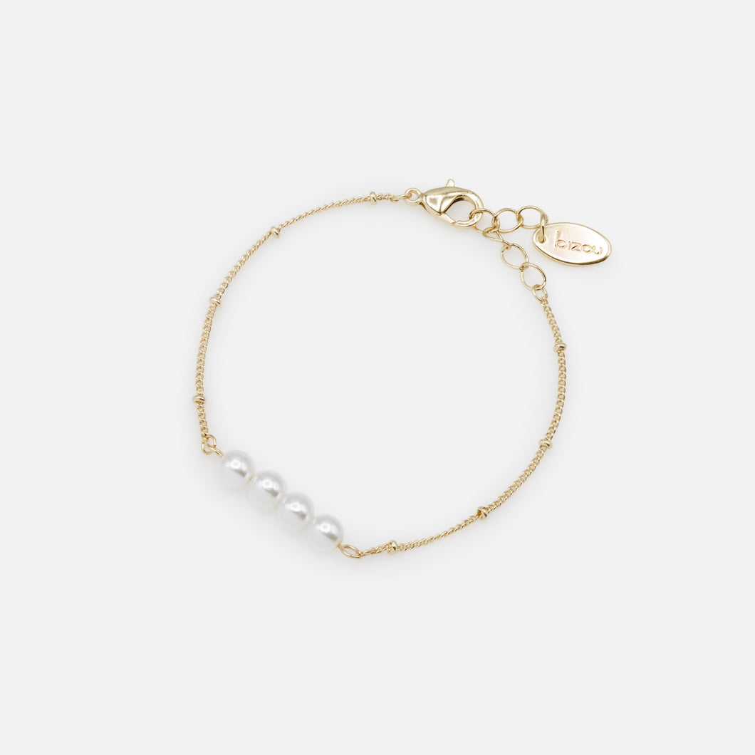 Golden bracelet with a quartet of synthetic pearls