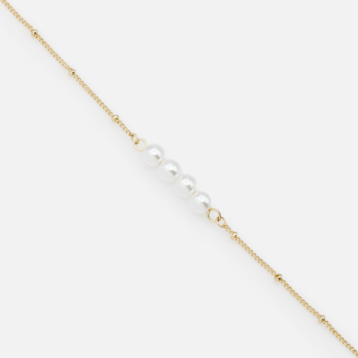 Golden bracelet with a quartet of synthetic pearls