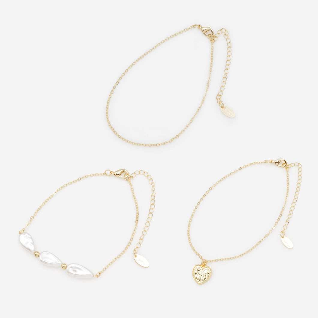 Trio of gold anklets with flat beads and textured heart