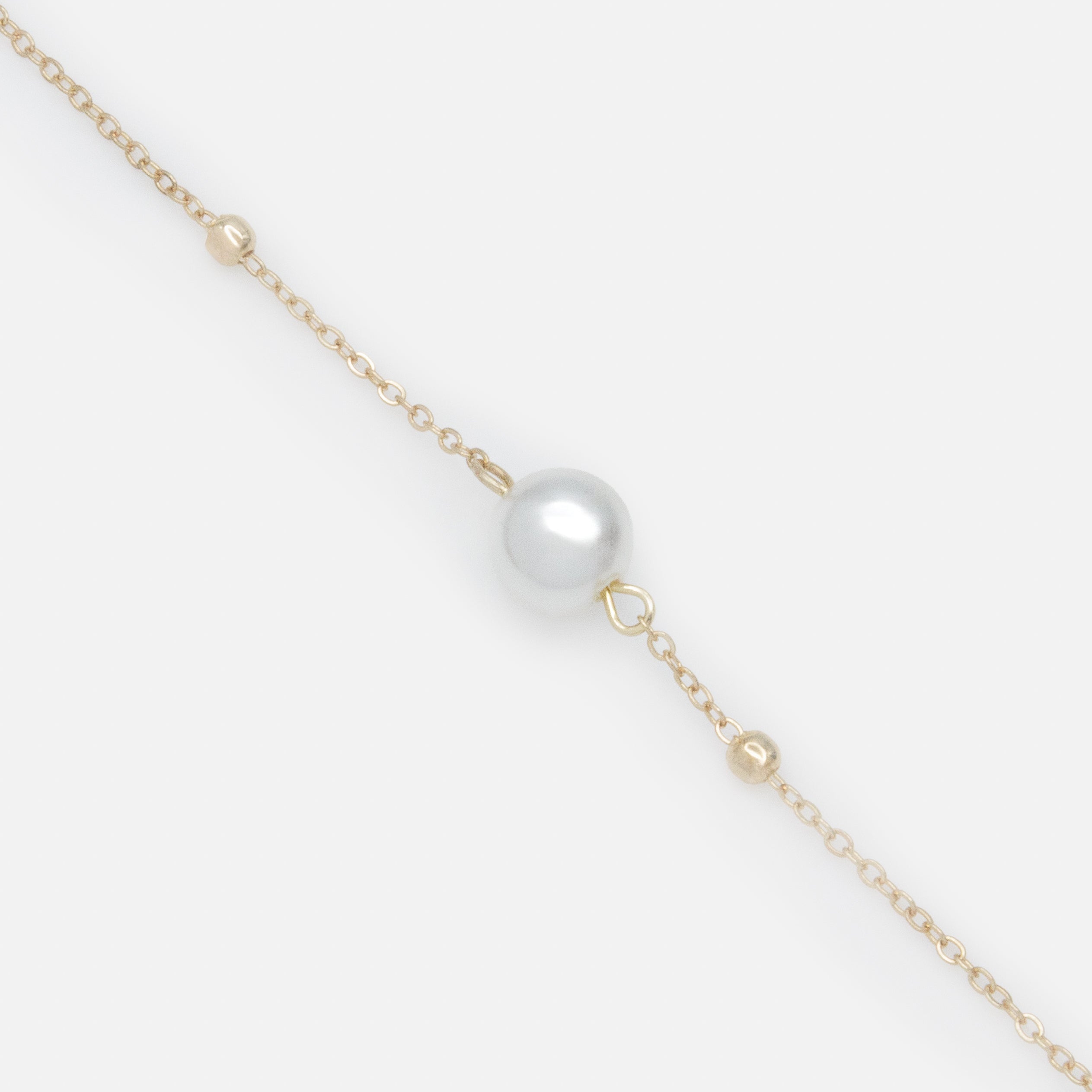 Bracelet doré avec fines billes et perle solitaire