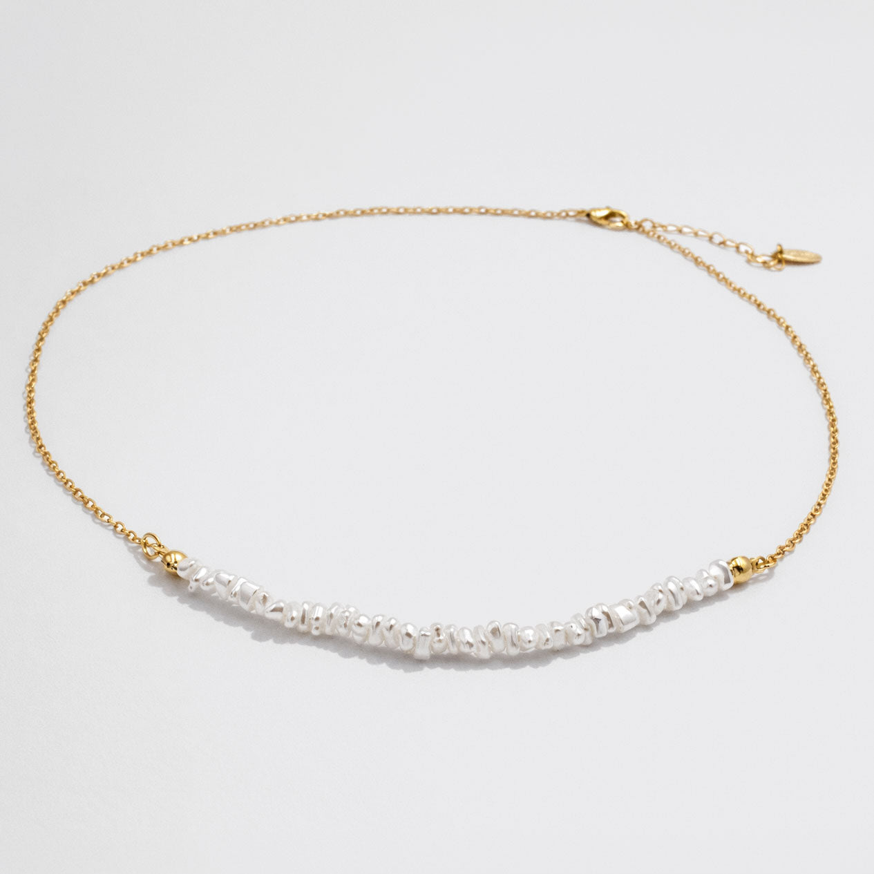 Collier doré délicat à rangée de perles asymétrique