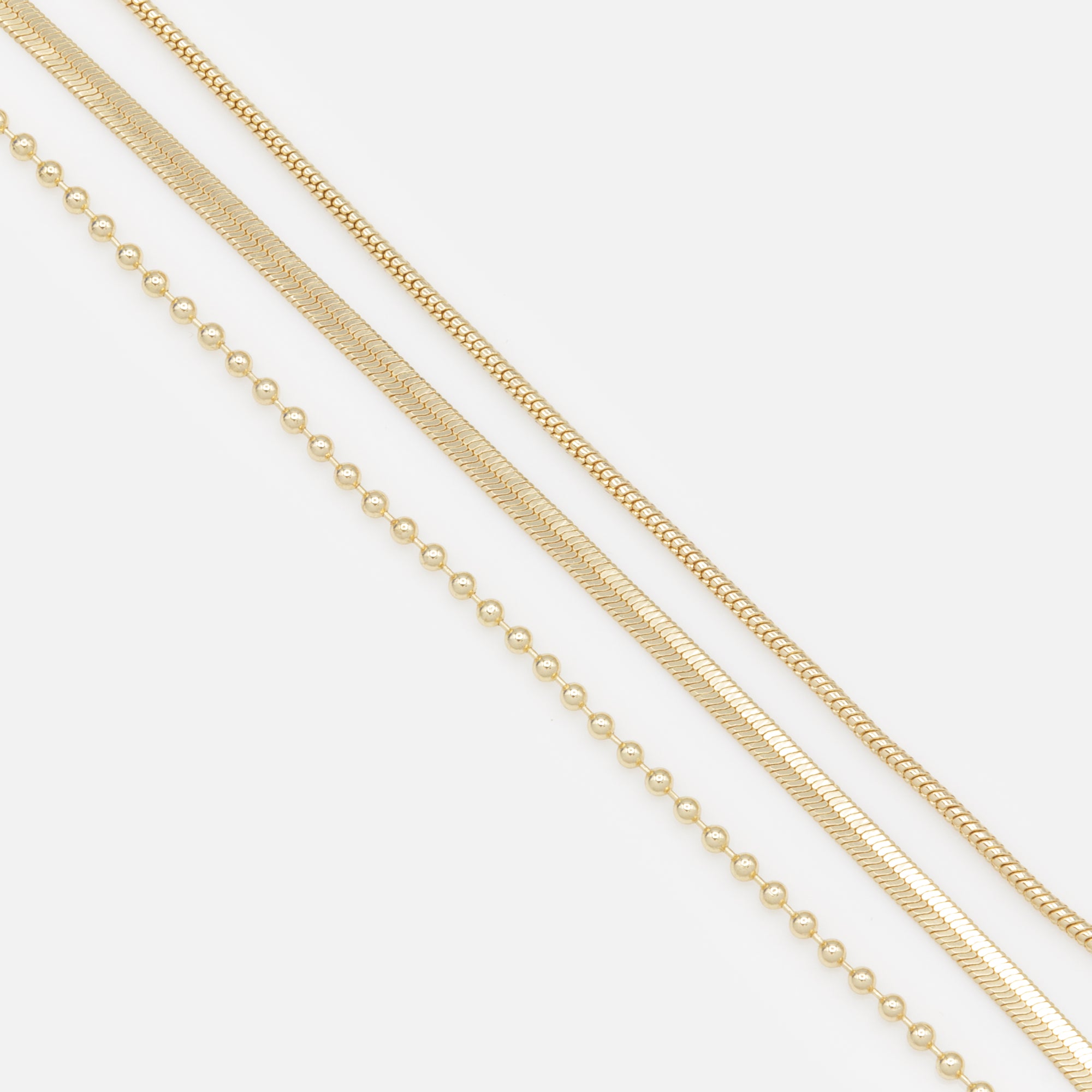 Trio of golden bracelets with varied links