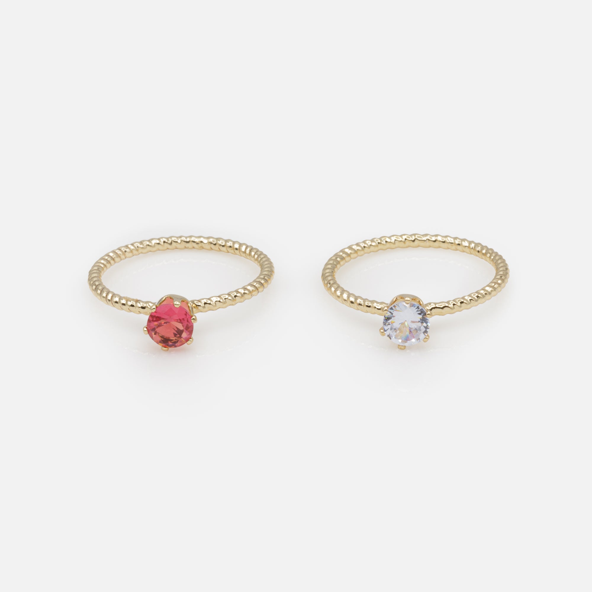 Duo de bagues dorées anneaux torsadés avec pierres rose et blanche