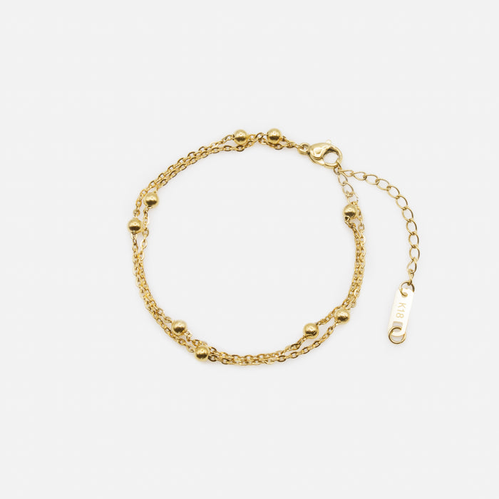Gold double chain bracelet with forced links and beads