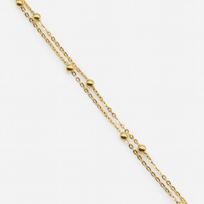Gold double chain bracelet with forced links and beads