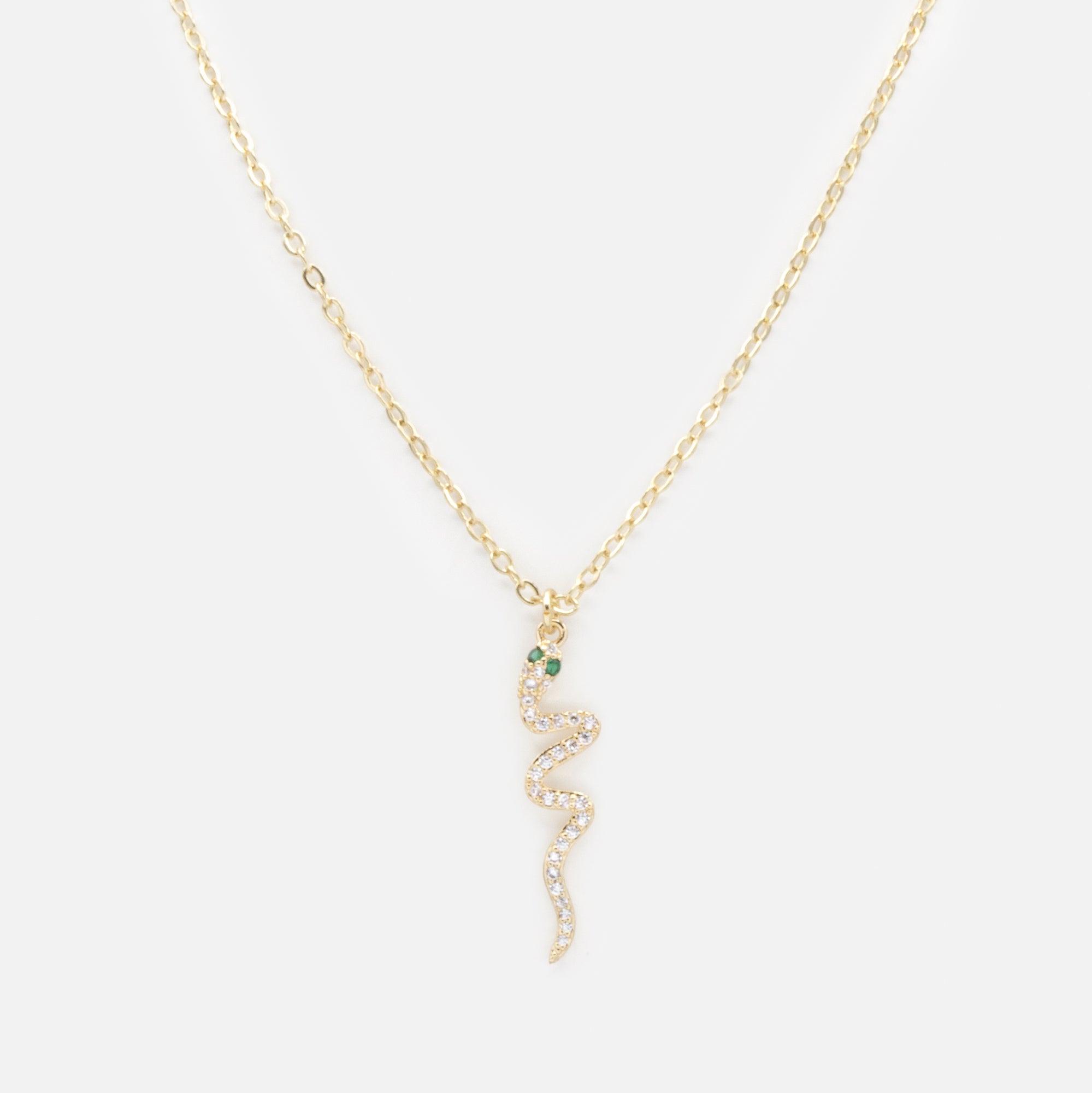 Gold snake charm necklace with cubic zirconia and emerald stones