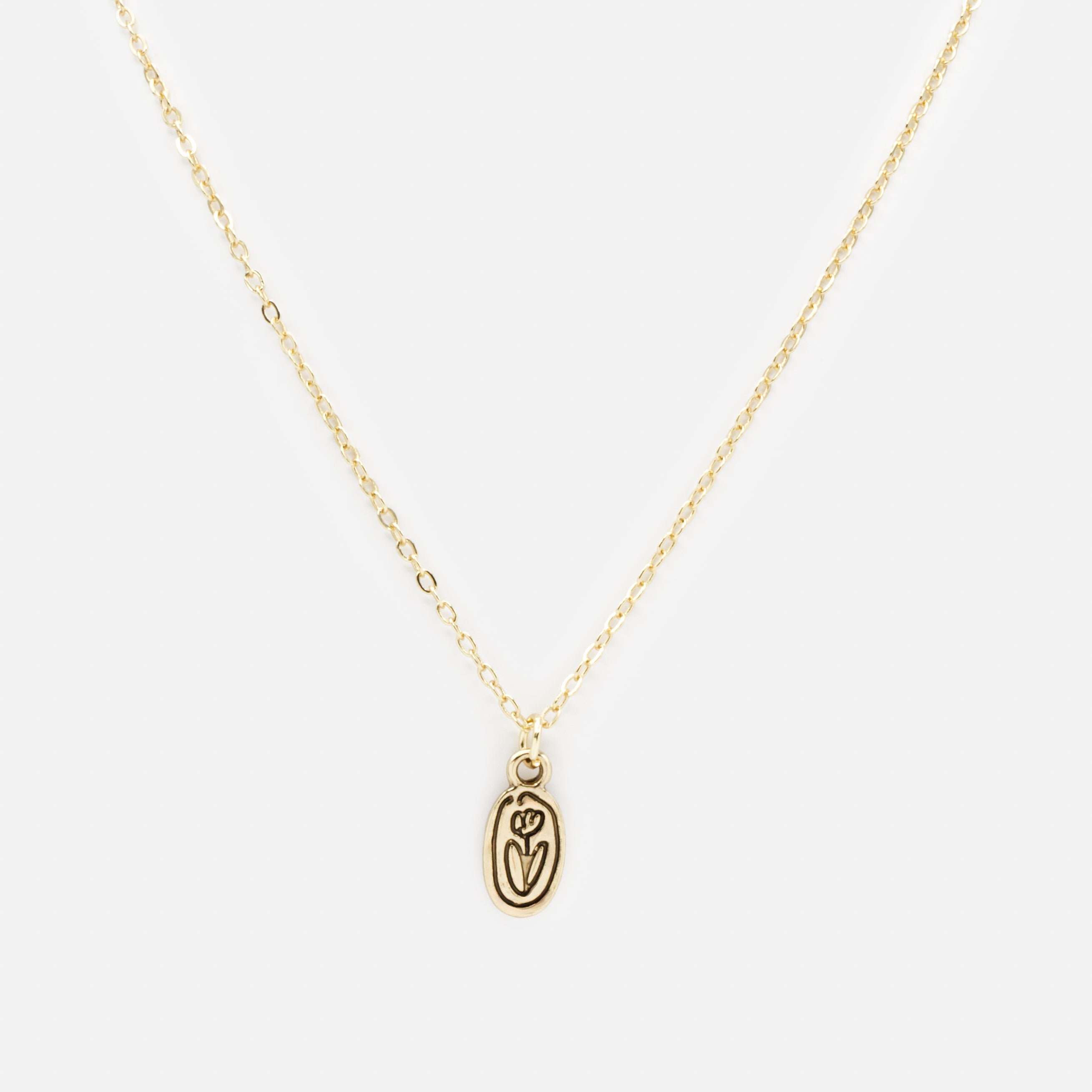 Gold necklace with black engraved flower charm