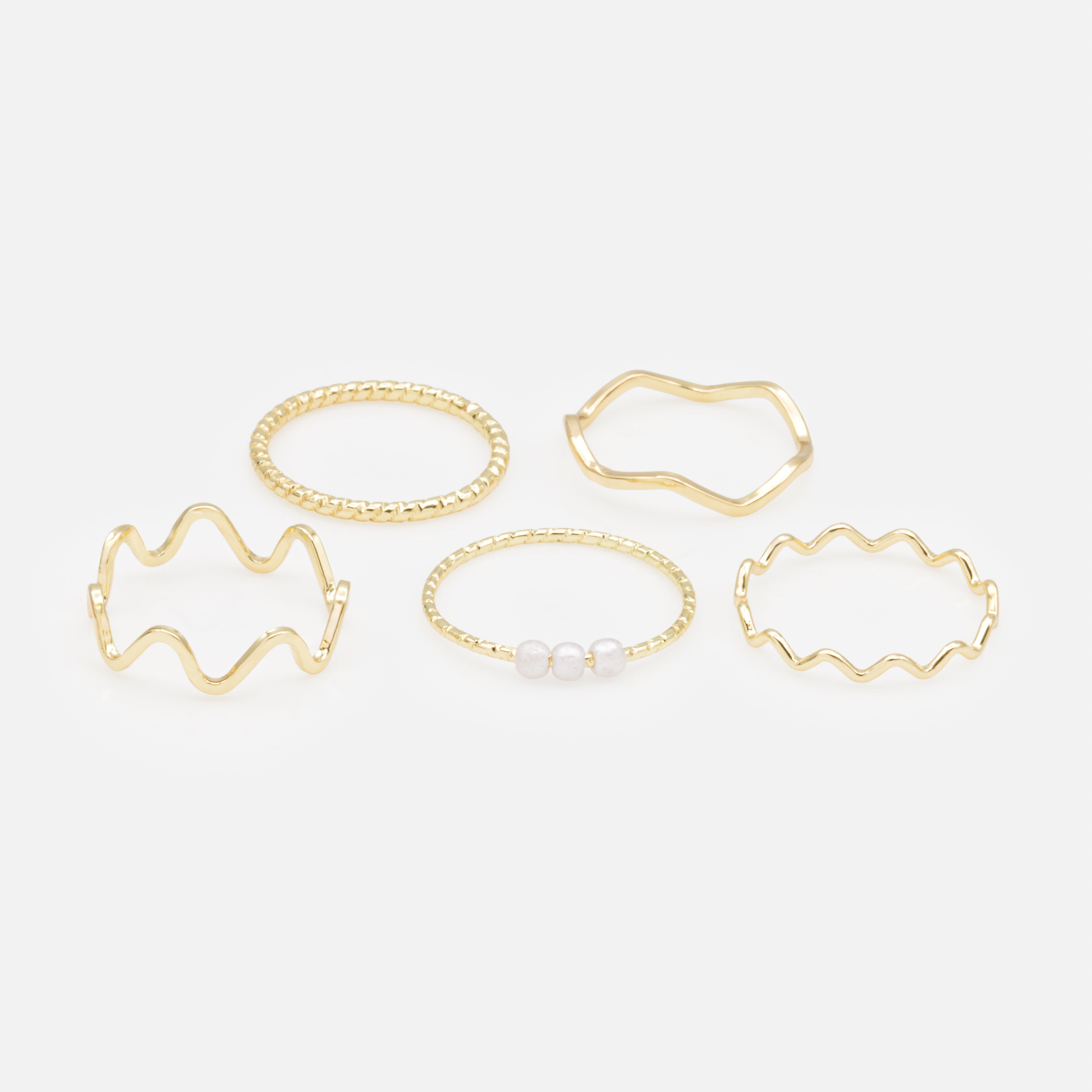 Ensemble de cinq bagues dorées de tailles variées avec effet vagues et petites perles