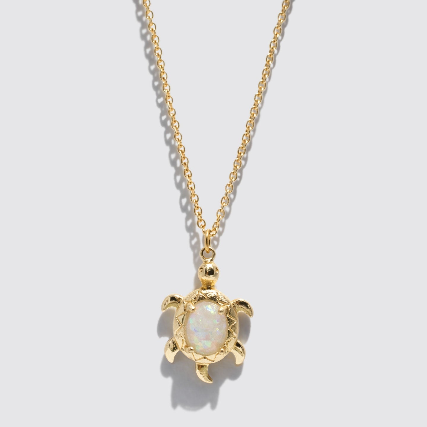 Collier doré à pendentif tortue effet opale
