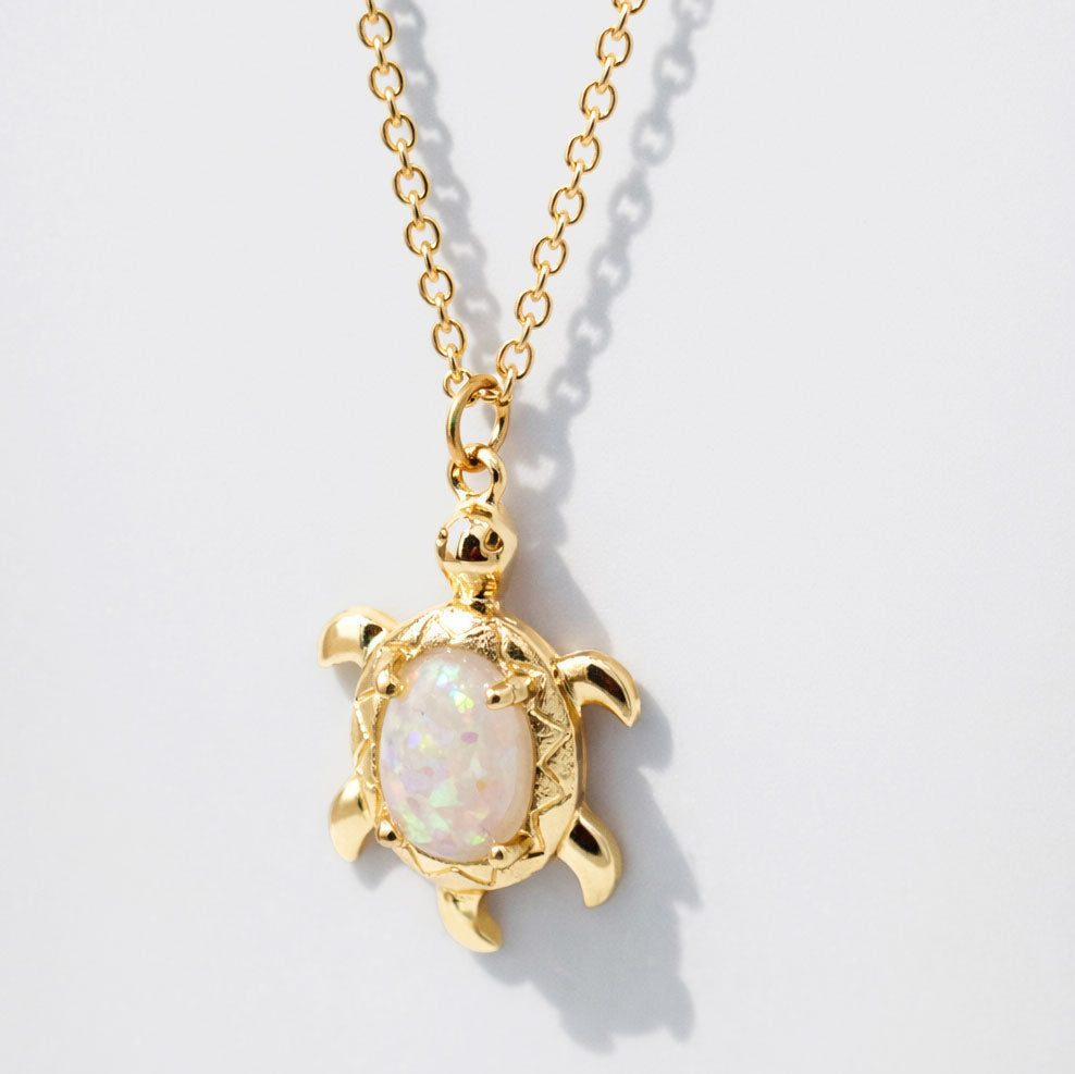 Collier doré à pendentif tortue effet opale