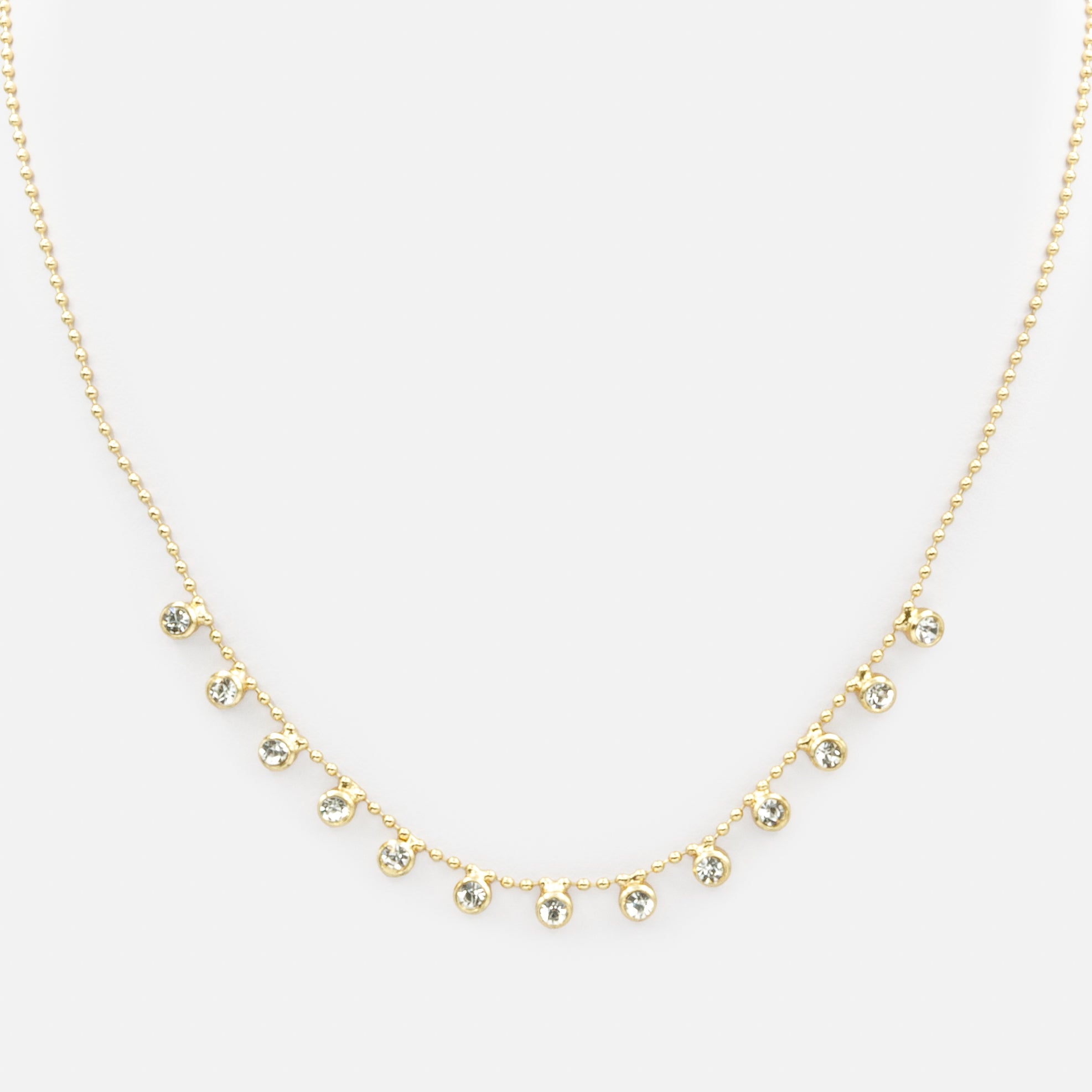 Collier de fines billes dorées avec breloques de zircons cubiques