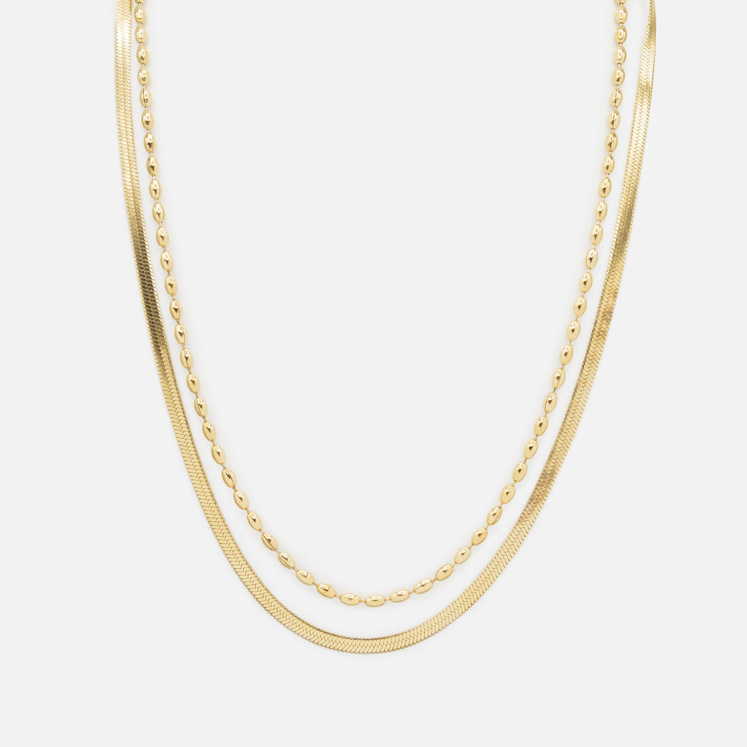 Gold double chain necklace with flat serpentine links and elongated stainless steel beads