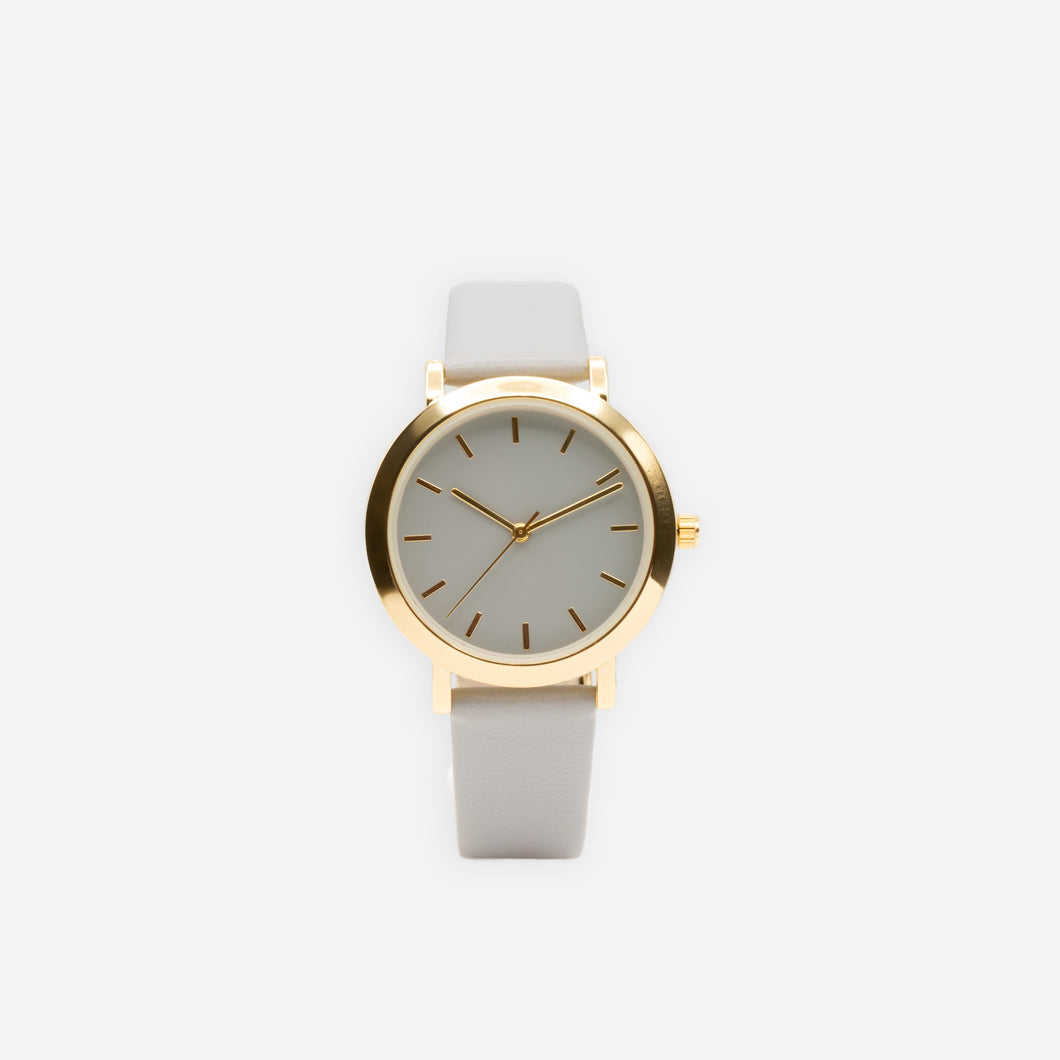Round watch with gold dial and gray strap