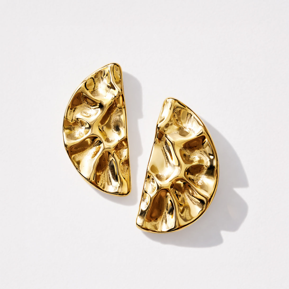 Bizou SF253E009GL – Gold hammered half-moon statement stud earrings in stainless steel, sculptural crinkled texture, flat lay view