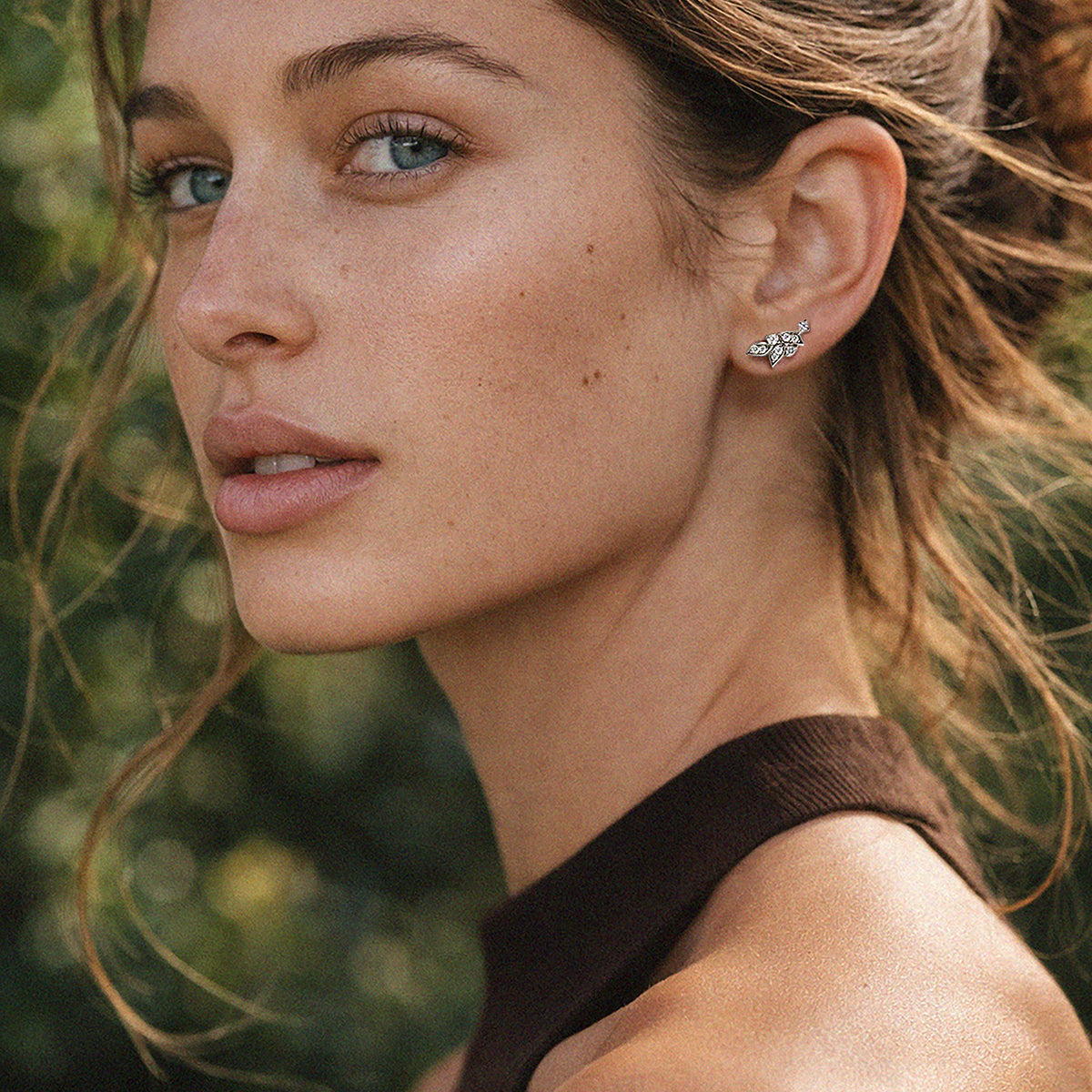 Bizou SS253E003SL – Woman wearing silver crystal leaf stud earrings in stainless steel, side profile, Bizou jewelry