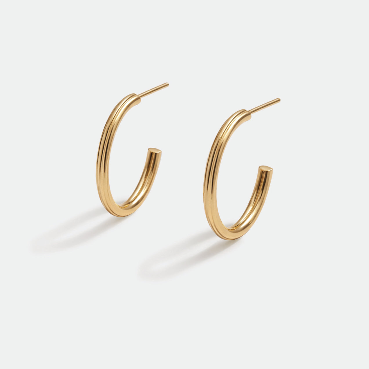 Bizou SS253E004GL – Gold grooved hoop earrings in stainless steel, tubular open hoop with ridge detail, angled view
