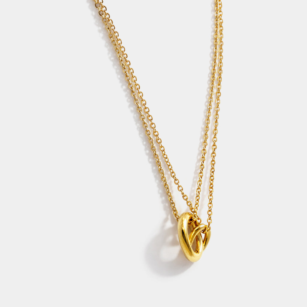 Bizou SS253N017GL – Close-up of gold stainless steel interlinked rings double chain necklace showing two interlocked tubular ring charms, angled view, Bizou jewelry

