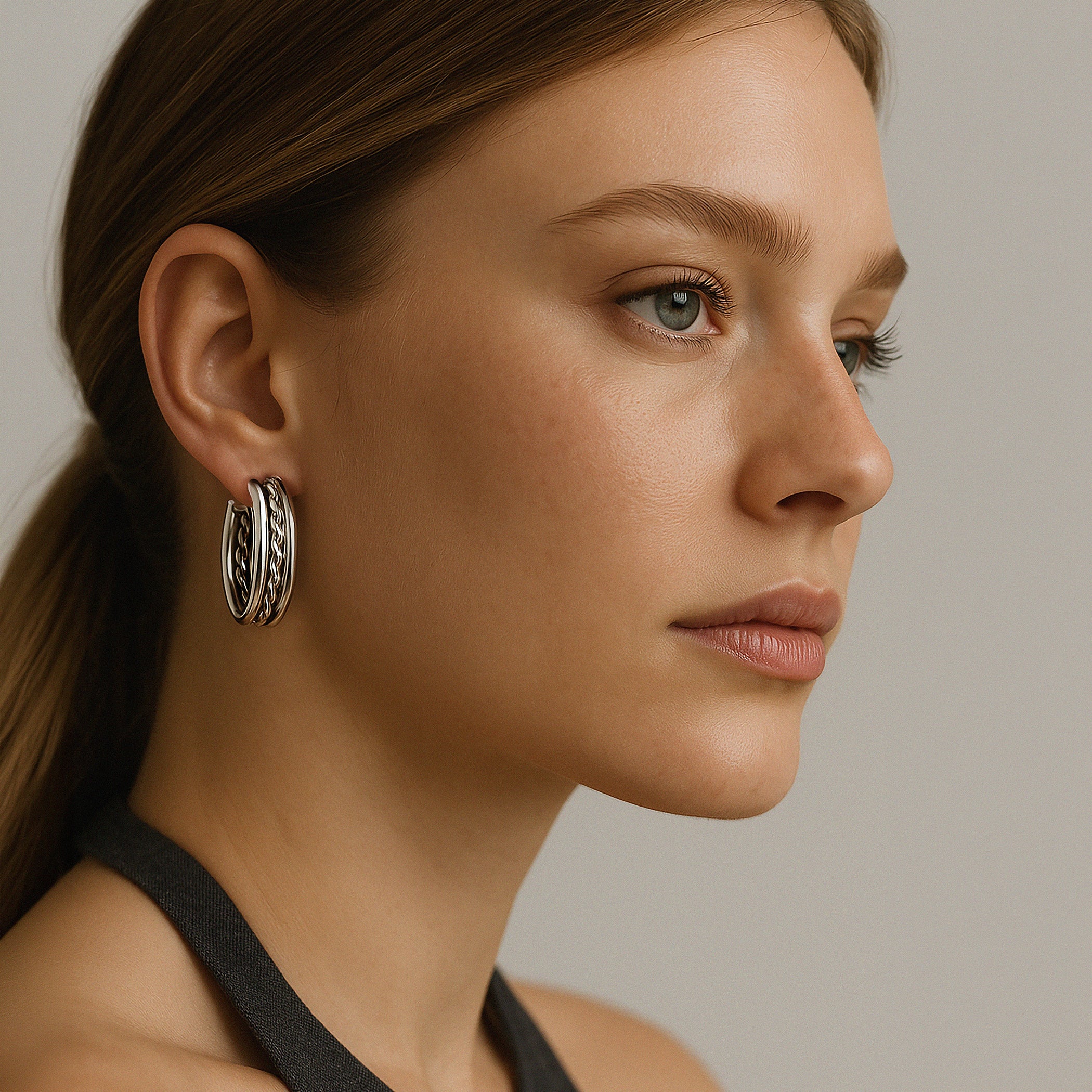 Silver twisted hoop earrings in stainless steel worn on model – Bizou jewelry