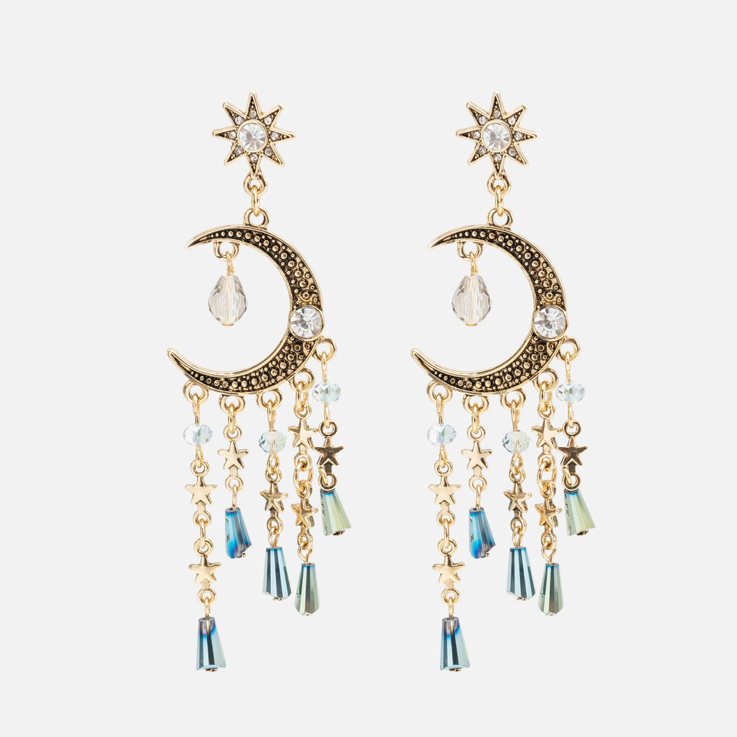 Long golden earrings with moon and star charms and multiple beads
