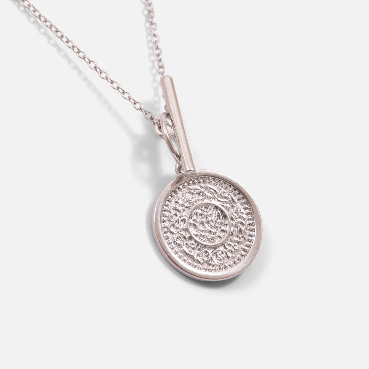 Silvered pendant with a coin charm and a round clasp and  bar