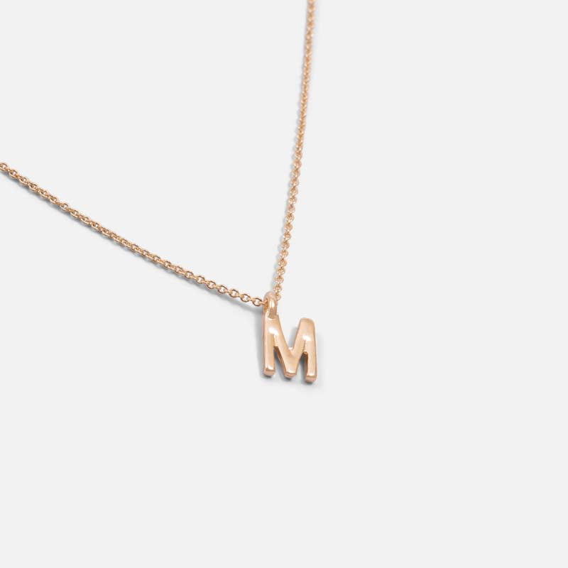 Golden pendant with letter m charm