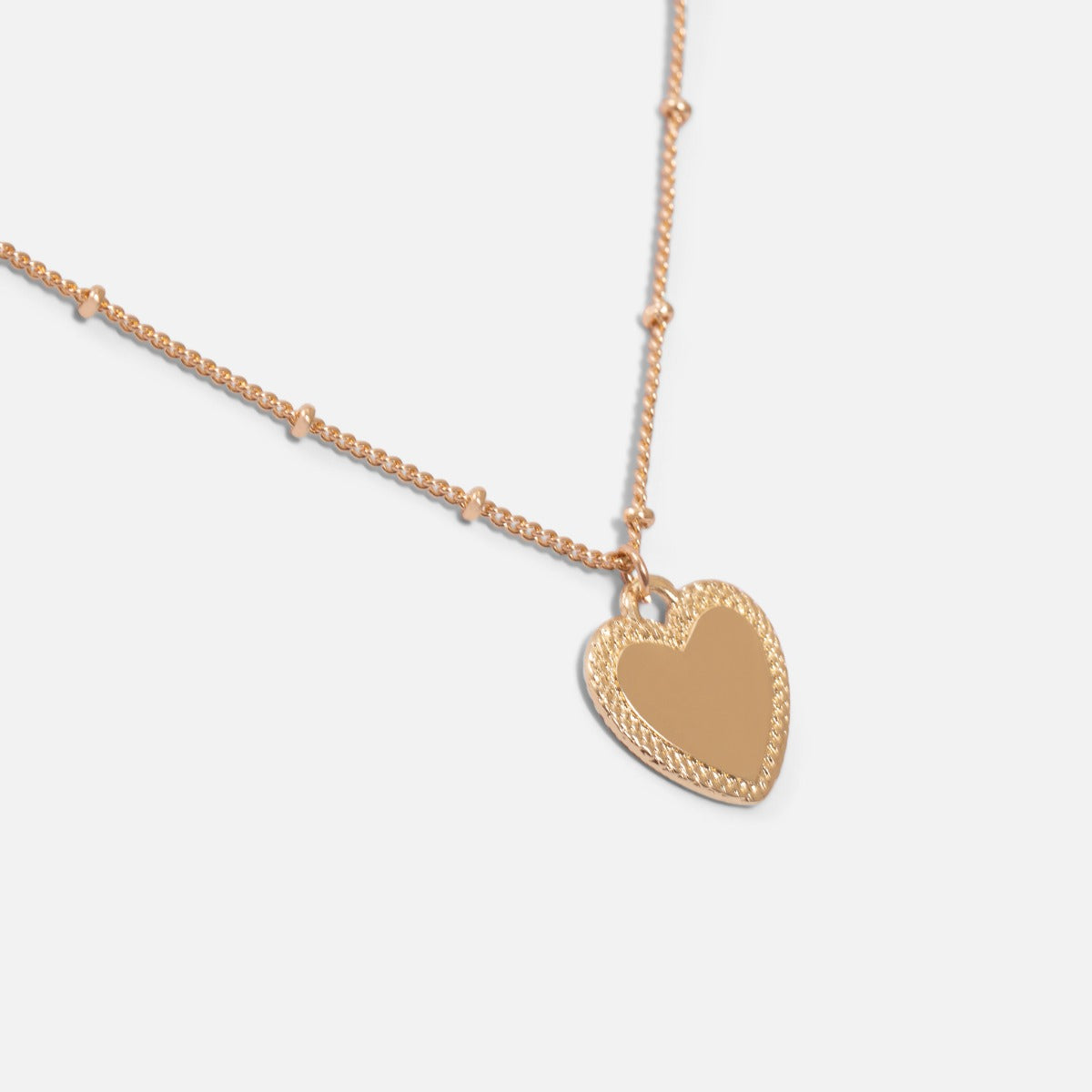 Golden pendant with small heart charm