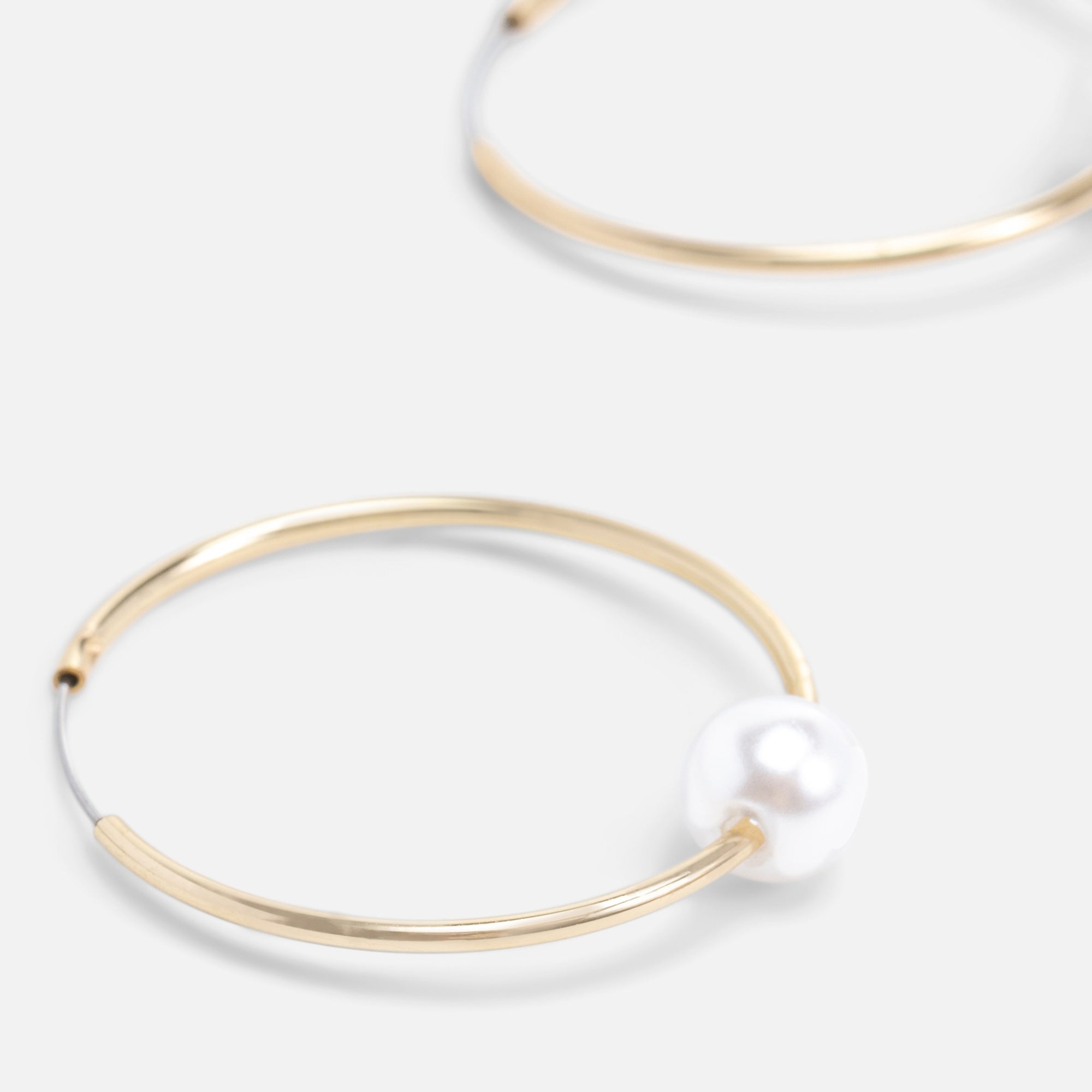 Golden hoop earrings with pearl insert