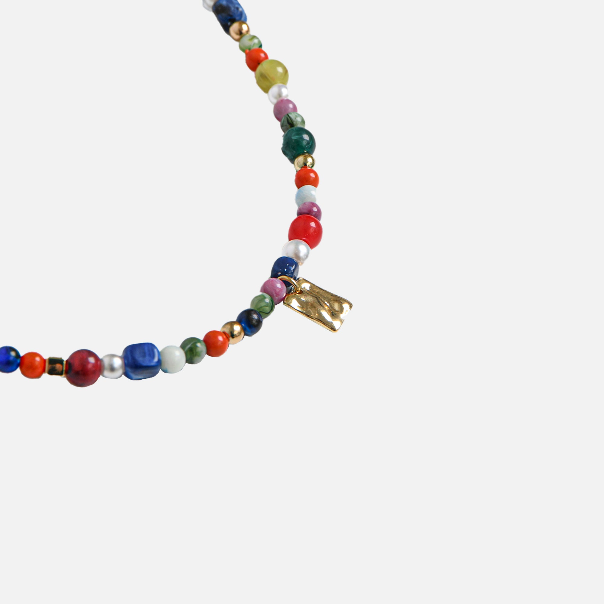 Collier de perles et billes multicolores avec breloque dorée