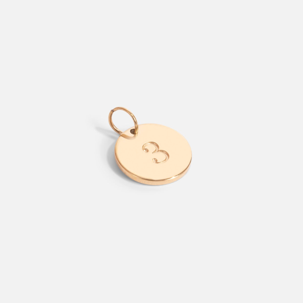 Small golden charm engraved with the number "3"   