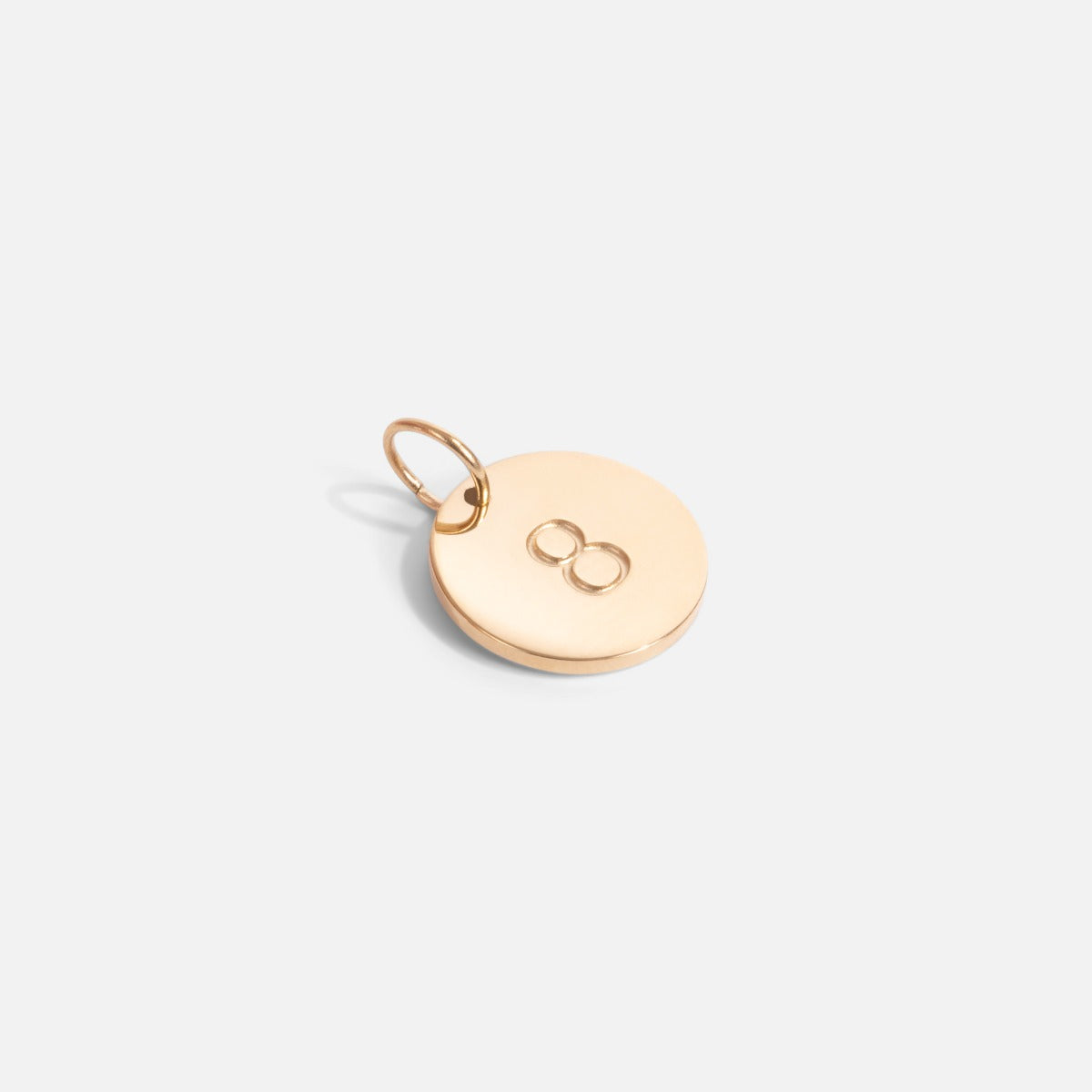 Small golden charm engraved with the number "8"   