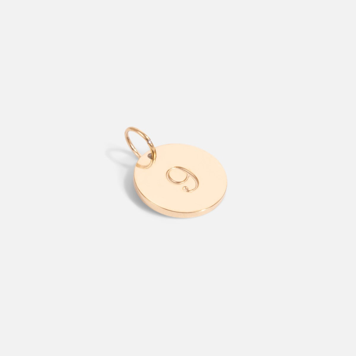 Small golden charm engraved with the number "9"   